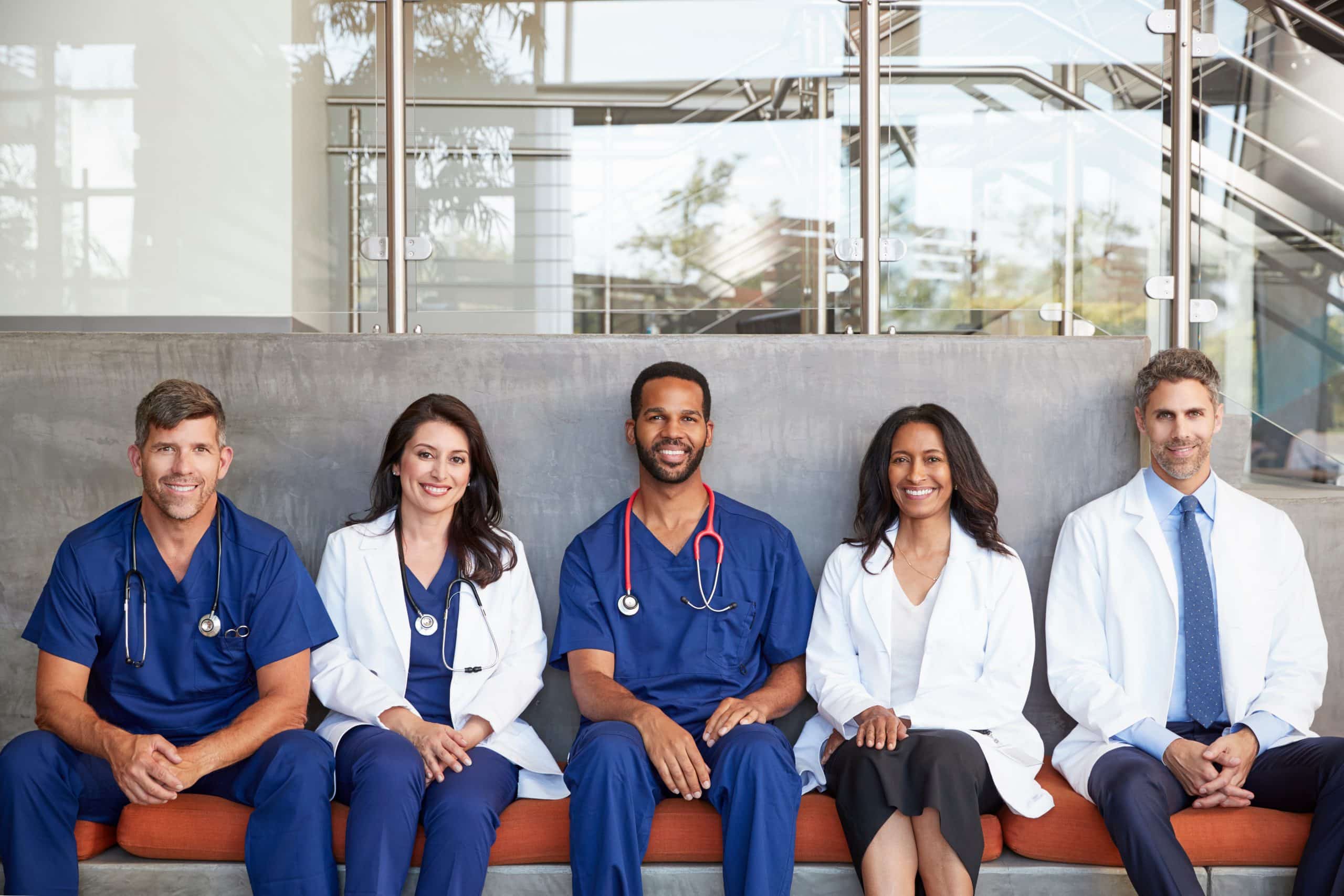 Healthcare workers sitting in hospital, three quarter length