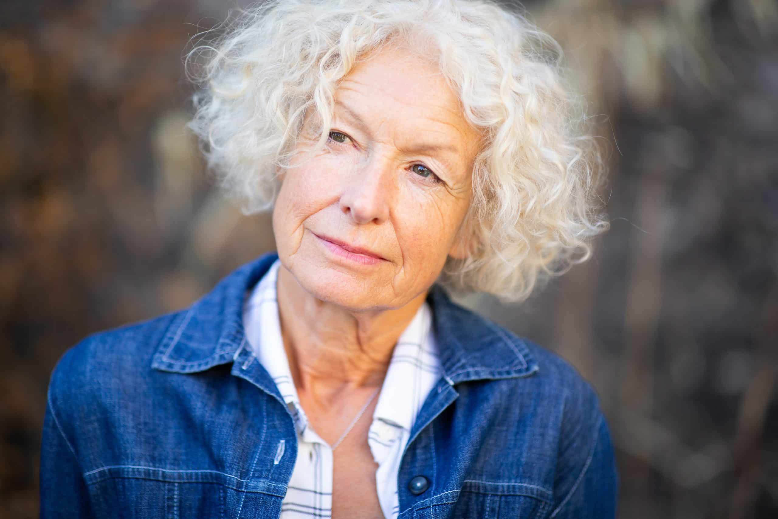 Close up portrait elderly woman glancing outdoors