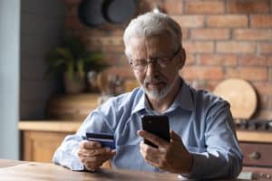 mature retired man shopping in mobile app.