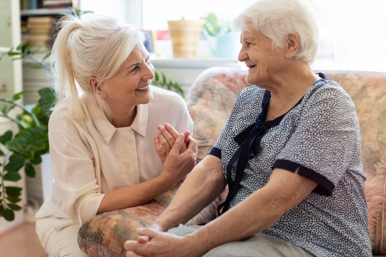 daughter talking to elderly mom dementia couch